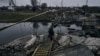 Росія без упину обстрілює Бахмут. На фото: жінка йде через підірваний міст у Бахмуті, 11 листопада 2022 року