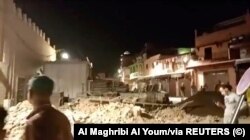 په مراکش کې خلک له زلزلې وروسته ورانو کورونو ته ګوري.