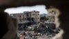 Palestinci stoje među ruševinama kuća uništenih u izraelskom napadu, usred privremenog primirja između Hamasa i Izraela, u Kan Younisu u južnom pojasu Gaze 24. novembra 2023.