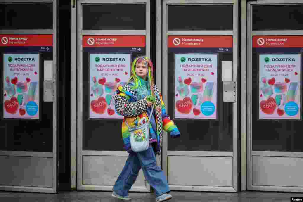 Žena izlazi iz stanice metroa ukrašene reklamnim posterima za Dan zaljubljenih, usred ruskog napada na Ukrajinu, u centru Kijeva, Ukrajina, 14. februara 2024. 