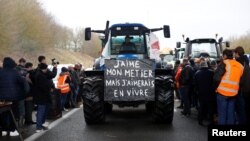 Poruka "Volim svoj posao, ali bih volio od njega da živim" na jednom od traktora kojima su poljoprivrednici blokirali autoput A16, blizu Beauvaisa, 23. januara 2024.