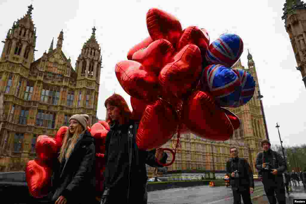 Djevojke koje nose balone u obliku srca šetaju u blizini Parlamenta na Dan zaljubljenih u Londonu, Velika Britanija, 14. februara 2024. 