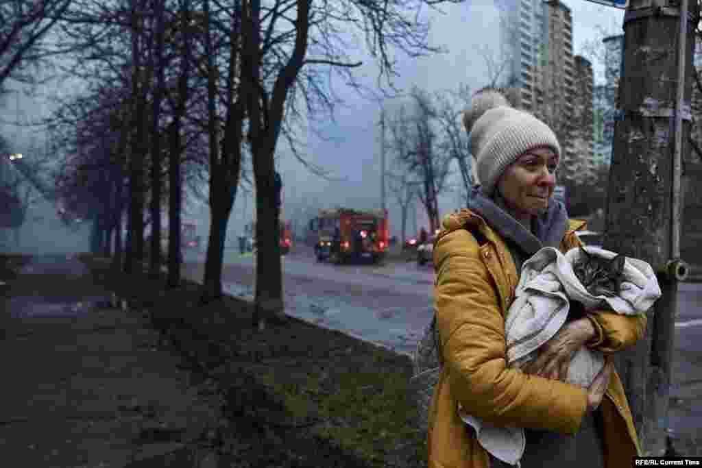 Женщина спасает кота из разрушенного дома, по которому ударила российская пакета, 2 января 2024 года. 