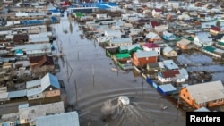 Pogled dronom prikazuje kamion koji se vozi poplavljenom ulicom u naselju Zarečnoje, oblast Orenburg, Rusija, 11. aprila 2024.