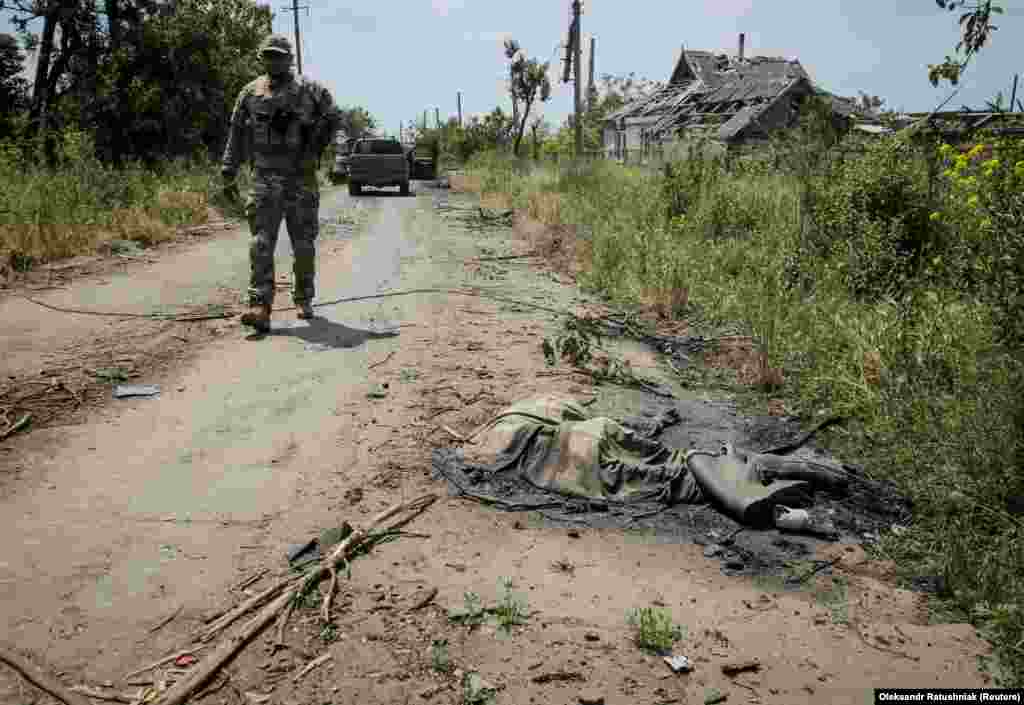 Украинский военный рядом с телом другого россиянина. Журналист агентства Reuters видели тела как минимум трёх российских военных на улицах Нескучного