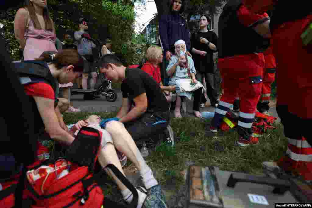 Медицинские работники оказывают помощь местным жителям, пострадавшим во время ракетного удара в Киеве, 8 июля 2024 года. Фото AFP