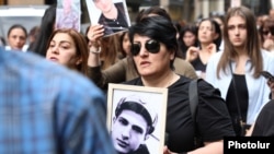 Armenia - Gayane Hakobian carries her son's picture during a 2022 demonstration in Yerevan.