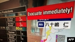 Ova slika snimljena u Hong Kongu 1. januara 2024. prikazuje poruku upozorenja na ekranu iz prijenosa uživo na NHK World u kojoj se traži od ljudi da se evakuišu iz tog područja nakon niza velikih potresa koji su pogodili centralni Japan.