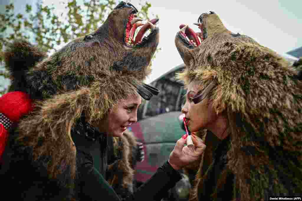 Žene u kostimima medvjeda šminkaju se pred otvaranje Međunarodnog festivala zimskih tradicija u Rumuniji, 16. decembra.