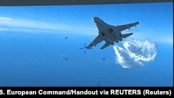Російський літак Су-27 скидає паливо над американським розвідувальним безпілотником MQ-9 над Чорним морем, 14 березня 2023 року, кадр із відео
