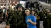 O tânără pozează cu un mercenar al grupării Wagner - cunoscută în Rusia ca o „companie militară privată” - înainte ca forțele de rebeliune să părăsească orașul Rostov pe Don, în sudul Rusiei, 24 iunie 2023.