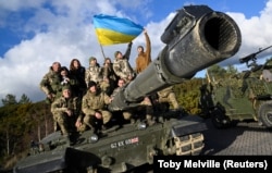 Українські військовослужбовці позують на танку Challenger 2 на військовій базі Bovington Camp на південному заході Великої Британії, 22 лютого 2023 року