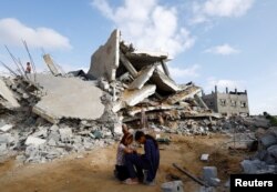 Palestinska djeca sjede među ruševinama u Rafahu, južno područje Pojasa Gaze, 21. april 2024.