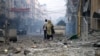 Palestinka gleda dok hoda ulicom punom ruševina u blizini tornja Watan, koji je uništen u izraelskim napadima, u gradu Gazi 8. oktobra 2023.