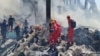 Armenia - Rescue workers sift through the rubble searching for possible survivors and recovering bodies at the site of a Yerevan shopping center where a fireworks warehouse exploded on August 14, triggering a massive fire.