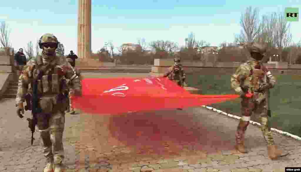 Оккупационные войска с советским знаменем победы с изображением серпа и молота в парке Славы в центре Херсона. Это копия флага, поднятого над берлинским Рейхстагом, и символ победы СССР над нацистской Германией 