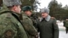 Александър Лукашенко във военна униформа инспектира учения. 
