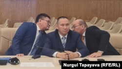 Кандидат от ОСДП Нурлан Ауесбаев (в центре), председатель ОСДП Асхат Рахимжанов (справа) и руководитель аппарата партии Талгат Омаров в ЦИК. Астана, 7 октября 2022 года