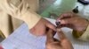 په چارسده کې انتخاباتي افسر د یو ووټر ګوته رنګوي - پخوانی انځور.