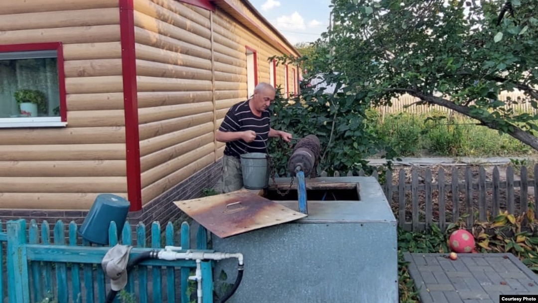 Мужчина пытается набрать воды в практически пересохшем колодце в Темиртау. Карагандинская область, сентябрь 2022 года 