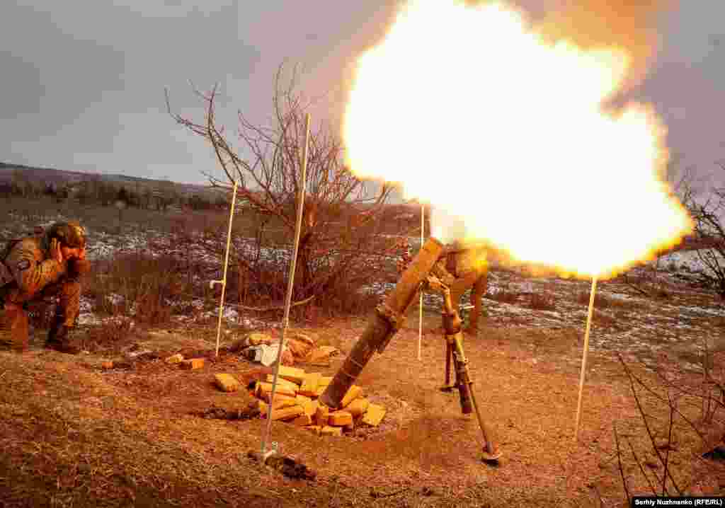 Украински войник стреля с миномет по руските позиции край Соледар на 14 януари. На 10 януари руски наемници от групировката "Вагнер" съобщиха, че са установили контрол над източния украински град, известен със своите солни мини. В действителност обаче боевете продължават.