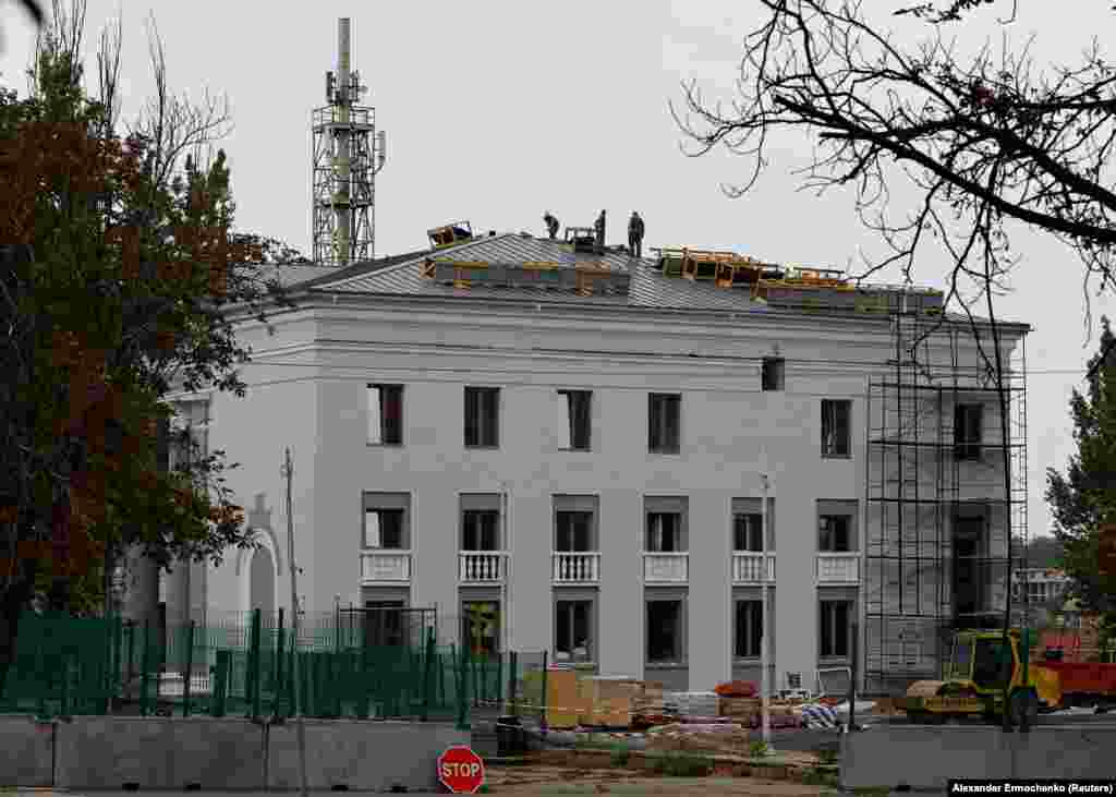На этом снимке от 21 августа строители восстанавливают здание мариупольской филармонии. Снимки здания драматического театра, на который российские войска сбросили авиабомбу 16 марта, что привело к гибели десятков мирных жителей и стало символом одной из самых смертоносных атак на мирное население за все время войны, обнародованы российскими властями не были. 