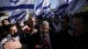 Izraelski zastupnik Itamar Ben-Gvir, okružen desničarskim aktivistima daje izjavu za medije prije marša u Jerusalemu, 20. aprila 2022. Nakon novembarskih parlamentarnih izbora, Ben-Gvirova stranka Vjerski cionizam, postala je treća najveća strankau Izraelu.