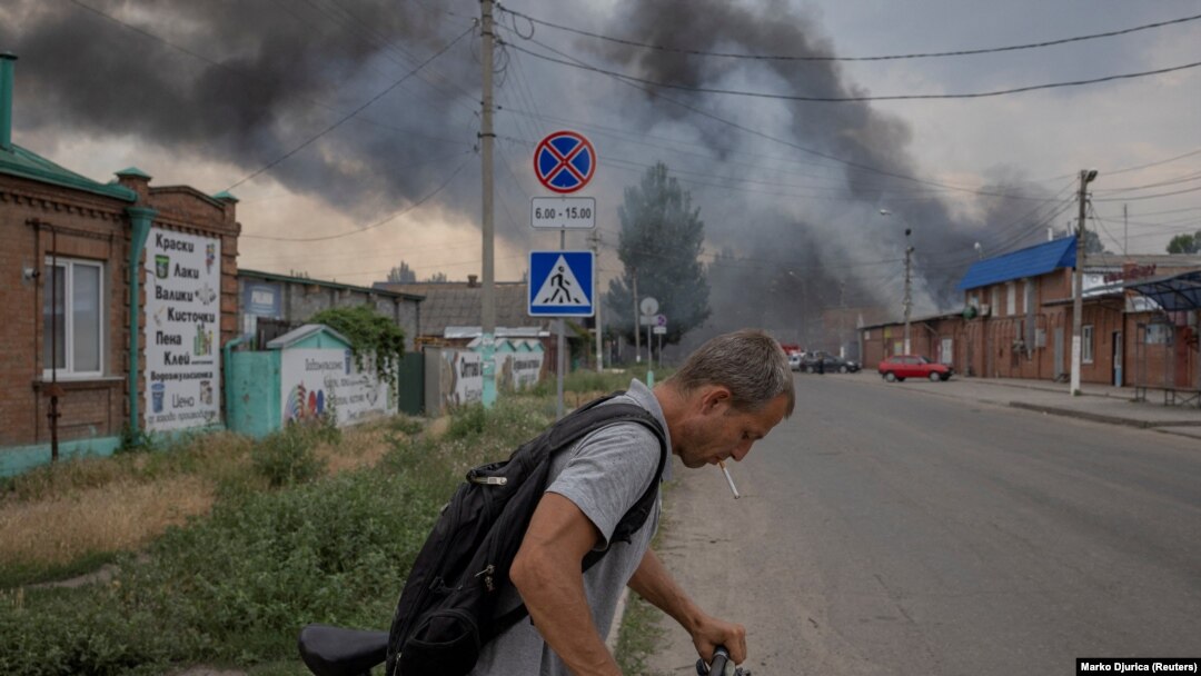 Мъж бута колелото си до пазара в Славянск, Донецка област, докато руският обстрел на града продължава. 5 юли 2022 г.