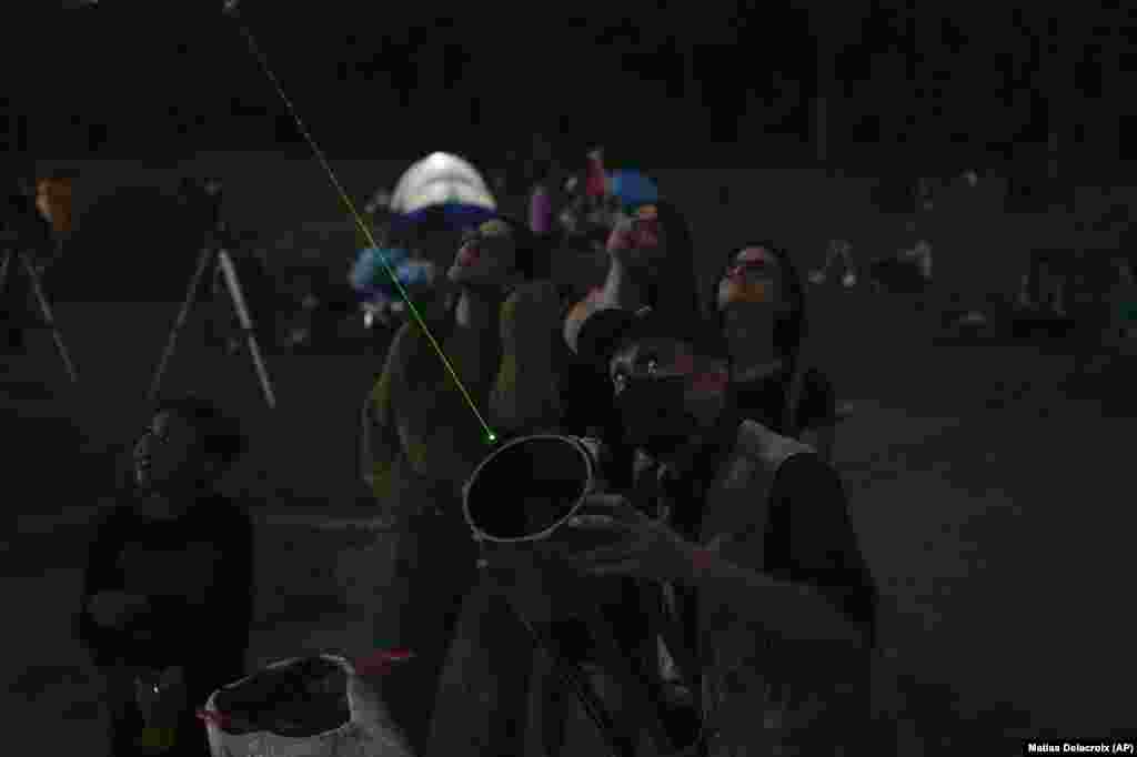 Un om îndreaptă un laser către Lună în Caracas, Venezuela, 15 mai 2022. Pasionaţii de astronomie au văzut cum Luna începe să se înroşească în partea din stânga. Din acel moment a început cea mai interesantă parte a fenomenului, intrarea Lunii în umbra Pământului. 