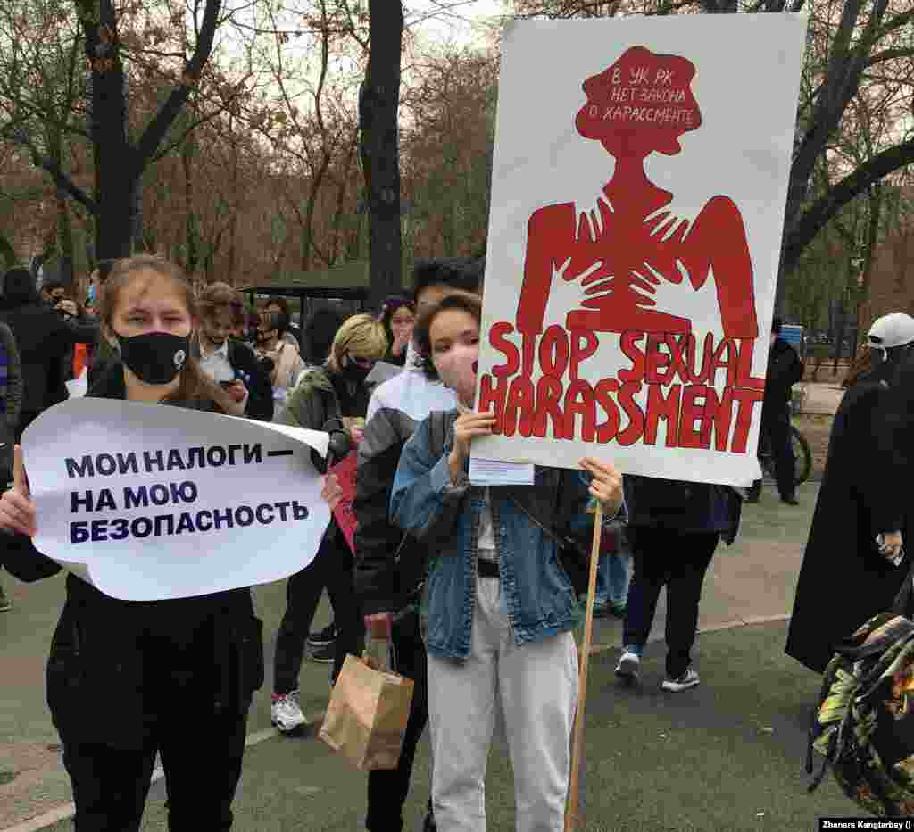 Шеруге келгендердің бірі "Жыныстық бопсалауды тоқтатайық" деген плакат ұстап тұр. 