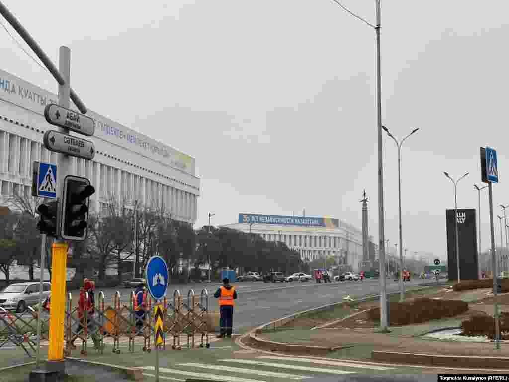Республика алаңына кіретін жолдар жабық, жұмысшылар көшені тазалап жүр. Жүргінші аз. 