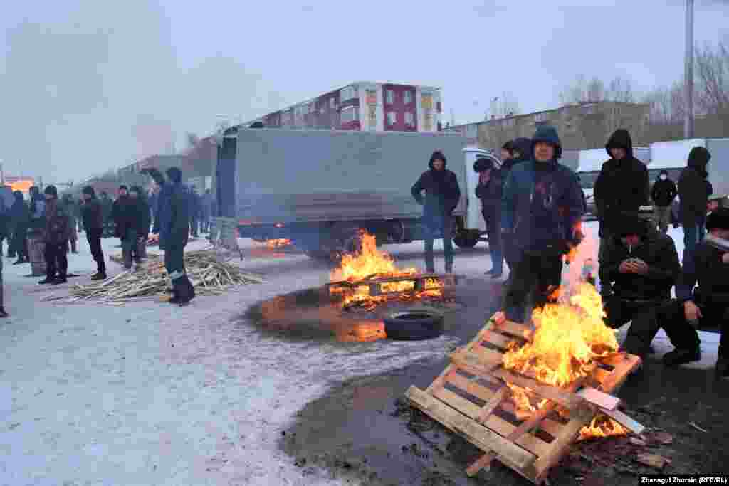 Суық күні алаңда от жағып жылынып отырған демонстранттар. Ақтөбе, 6 қаңтар 2022 ж.