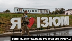 Орыс әскерінен азат етілген Изюм қаласында кетіп бара жатқан украин жауынгері.