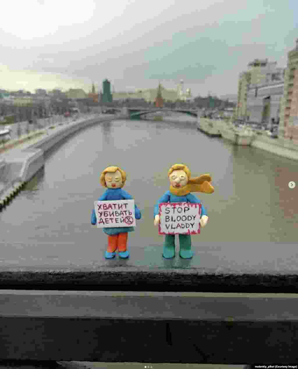 Фигурки перед Кремлем на мосту через Москву-реку. На плакате женщины написано: «Хватит убивать детей». Россияне, размещающие такие фигурки протеста в общественных местах, почти наверняка столкнутся с длительными сроками тюремного заключения, если их поймают