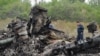 Спасатель на обломках малайзийского лайнера в Донецкой области Украины. 18 июля 2014 года. 