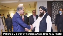 د طالبانو د بهرنیو چارو سرپرست وزیر امیر خان متقي(چپ) د پاکستان د بهرنیو چارو له وزیر شاه محمود قریشي سره په اسلام اباد کې،۱۸ دسمبر ۲۰۲۱