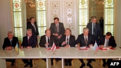 Прем’єр-міністр України Вітольд Фокін (перший ліворуч), президент України Леонід Кравчук (другий ліворуч), голова Верховної Ради Білорусі Станіслав Шушкевич (третій ліворуч) і президент Росії Борис Єльцин (другий праворуч) під час підписання Біловезької угоди, 8 грудня 1991 року