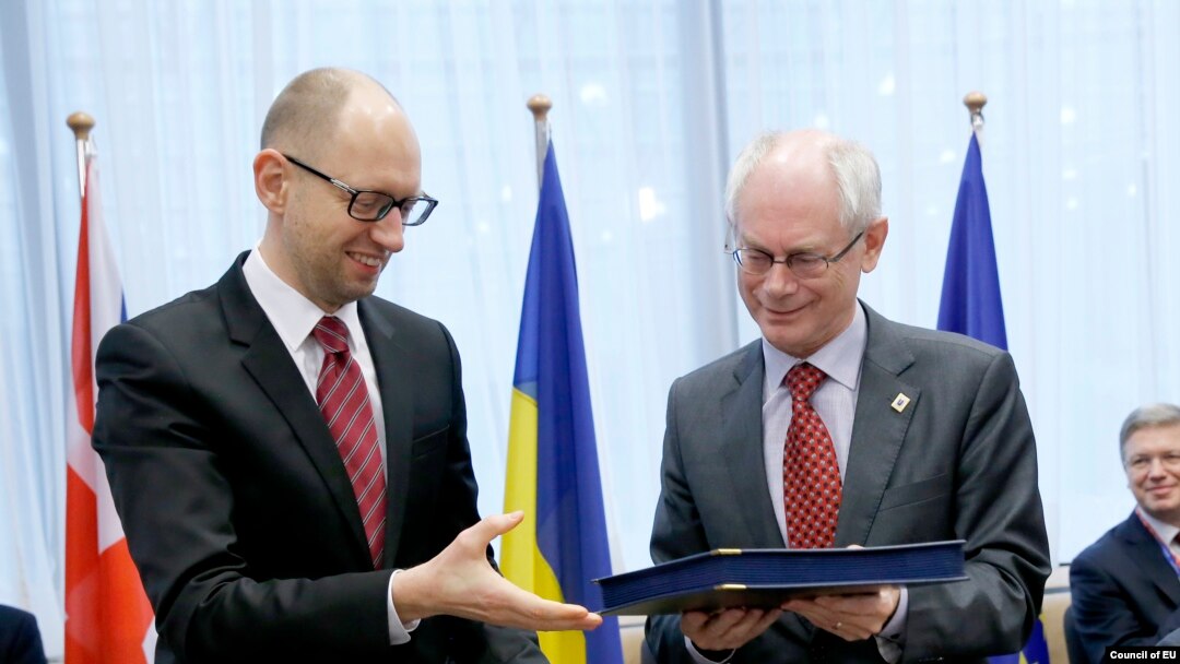 Avropa Şurasının prezidenti Herman Van Rampuy (sağda) və Ukraynanın Baş naziri Arseniy Yatsenyuk Ukrayna ilə Avropa Birliyi arasında siyasi əməkdaşlığa dair imzaladıqları sənədləri dəyişirlər. Brüssel, 21 mart 2014