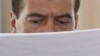 Президенти вақти Русия Дмитрий Медведев, ҳини мутолиаи санадҳо, қабл аз як нишаст роҷеъ ба фасод ва ришвахорӣ миёни мансабдорони рус дар моҳи марти соли 2012. Акс аз бойгонӣ.
