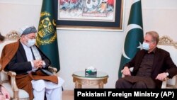 د عکس ښي لور ته د پاکستان د بهرنیو چارو وزیر شاه محمود قریشي او چپ لور ته د حزب وحدت اسلامي افغانستان مشر محمد کریم خلیلي
