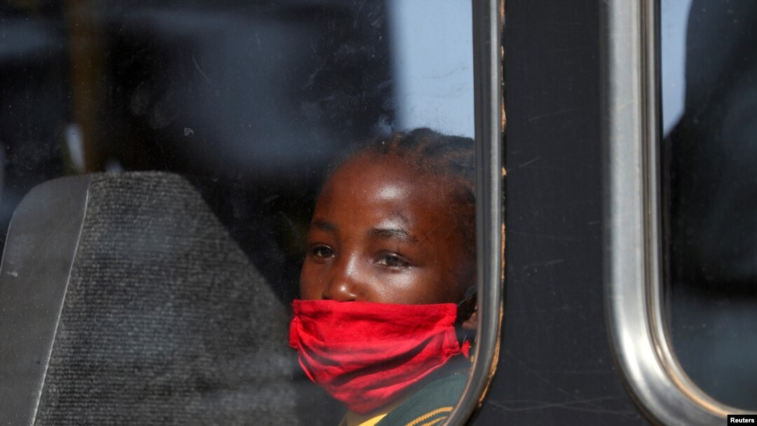 Djevojčica sa zaštitnom maskom gleda kroz prozor autobusa, Južna Afrika, 24. avgusta 2020. 