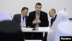 Cei trei lideri ai opoziției, Oleh Tiahnibok (stânga), Vitali Kliciko (centru) și Arkadi Iațeniuk discutând cu reprezentanți ai cultelor la Kiev, 25 iqnuqrie 2014.
