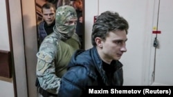 Один із полонених моряків – старший матрос судна «Нікополь» В’ячеслав Зінченко під конвоєм, Москва, 15 січня 2019 року