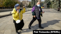 Алматыдағы митингіде өзара тәжікелесіп қалған ер мен әйел. 31 қазан, 2020.