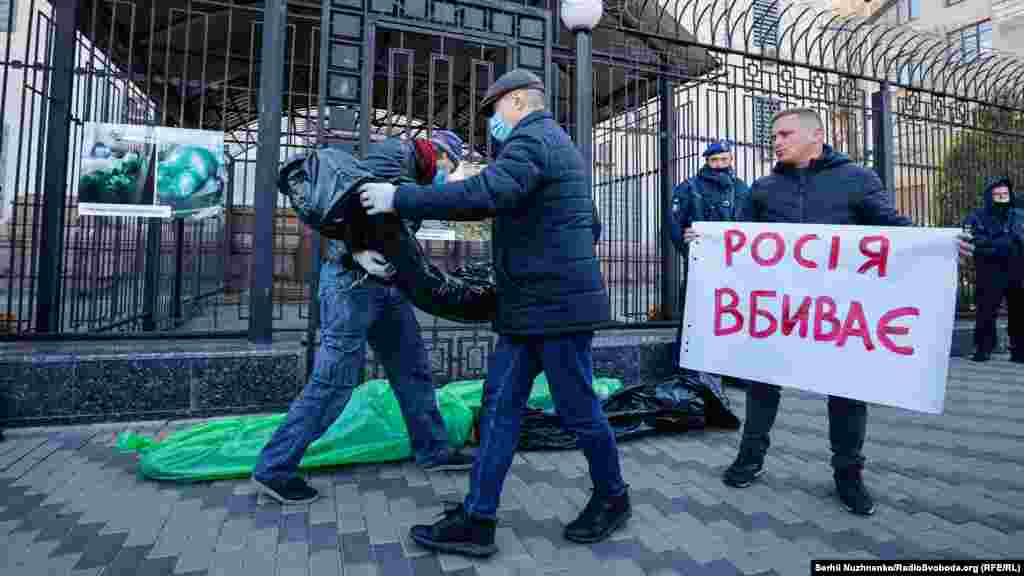 Учасники акції виклали перед парканом російського посольства у Києві загорнуті у поліетилен символічні «тіла померлих»
