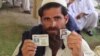 پېښور کې د احتجاج پرمهال د خپلې کورنۍ د ورک تن شناختي کارډ په لاس یو احتجاجي