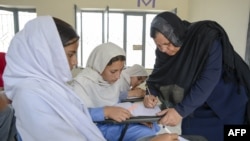 له ارشیفه د یوې افغانې ښوونکې او څو زده کوونکو تصویر