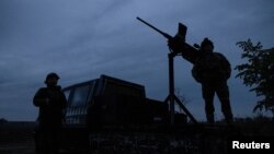 FILE PHOTO: Members of a mobile air defence volunteer unit stand next to their machine gun during the most massive Russian drone attack in Kyiv region