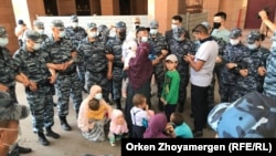 Баглан Орынбеков с женой и детьми в полицейском кольце. Нур-Султан, 25 мая 2021 года.