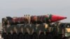 Pakistani military personnel stand beside a Shaheen III surface-to-surface ballistic missile during a military parade on March 23, 2017.